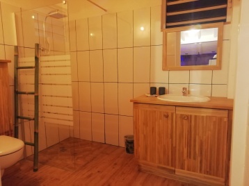 Salle d'eau avec sa douche à l'Italienne et meuble bambou.