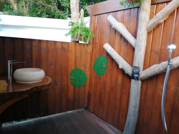 Le must de Bwa Majorelle! Sa douche tropicale conçue à ciel ouvert avec des bois locaux dont un Tendacayou et un Bois d'Inde. Lavabo en pierre et support en bois rouge Courbaril.
